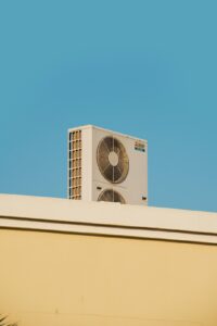 Homeowner checking a vent and thermostat in a living room, with visible concern about cooling performance.