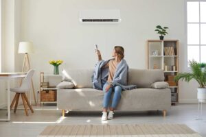 A person inspecting and changing a furnace filter in a home basement utility room.
