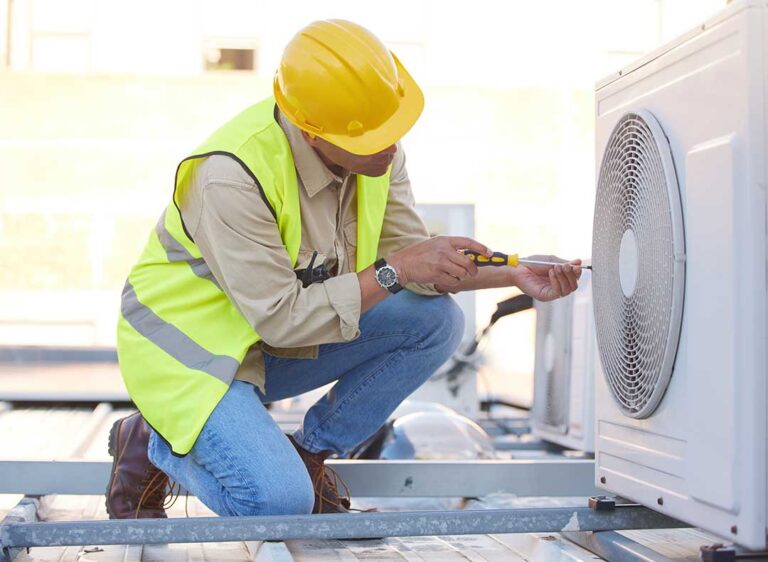 A homeowner adjusts a wall thermostat while a furnace and heating vents are visible in the background.