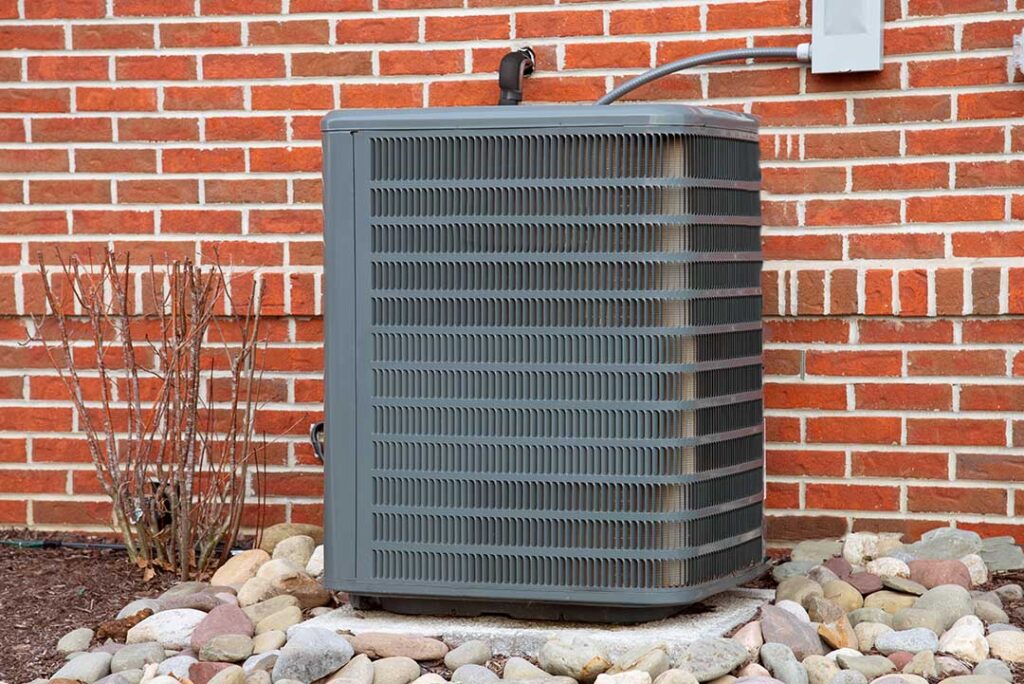 A family stands outside a home while a carbon monoxide alarm and furnace vent are visible nearby.